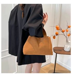 Detail of a brown suede tote bag with a minimalist design and soft textured finish