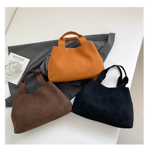 Close-up of minimalist suede tote bags in dark brown, ginger yellow and black colors