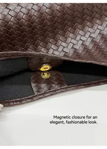Détail d'un sac en cuir tressé marron foncé avec fermeture magnétique dorée et doublure interne