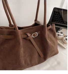 Close-up of vintage dark brown suede tote bag featuring a silver metal buckle detail