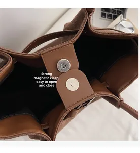 Detail of a brown tote bag featuring a strong magnetic silver clasp and interior lining