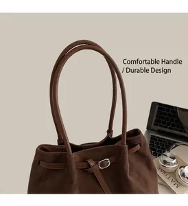 Detail view of the deep brown faux suede tote bag featuring a metallic silver buckle