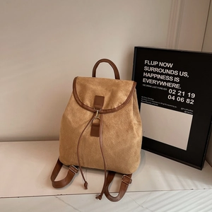 Retro camel suede backpack with leather trim and drawstring closure in minimalist setting