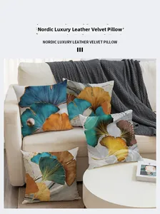 Detailed close-up of velvet ginkgo leaf pillow covers in blue and gold on a white sofa