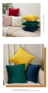 Detail of velvet cushion covers with pom-pom trim in a variety of vibrant solid colors