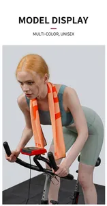 Orange cooling sports towel used by a model on a stationary bike in a gym setting