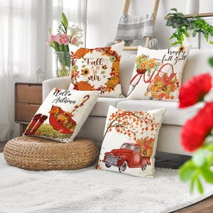 Set of four linen fall throw pillow covers with pumpkin and truck designs on sofa