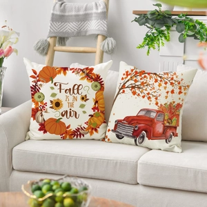 Linen autumn throw pillow covers featuring pumpkins and maple leaves on a sofa