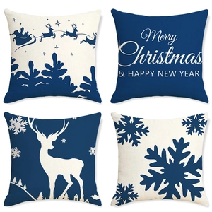 Détail de quatre housses de coussin de Noël avec motifs rennes et traîneau bleu marine