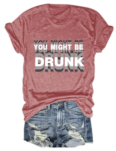 Détail d'un t-shirt rouge brique avec slogan et d'un short en jean délavé et déchiré