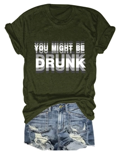 Détail du t-shirt vert foncé avec texte YOU MIGHT BE DRUNK et short en jean vieilli