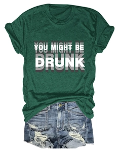 Détail du t-shirt vert foncé avec texte imprimé et short en jean bleu effiloché