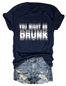 Mise à plat d'un t-shirt bleu marine à slogan et d'un short en jean usé sur fond blanc