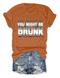 Détail du t-shirt orange avec imprimé You Might Be Drunk et short en jean vieilli