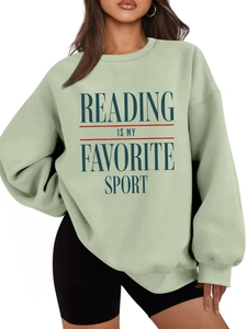 Detail of mint green sweatshirt featuring blue Reading Is My Favorite Sport print text