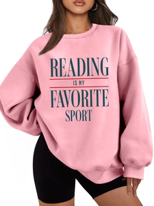 Close-up of Reading Is My Favorite Sport text print on pink oversized sweatshirt