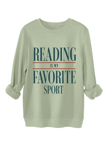 Close-up of reading is my favorite sport text on a light green long sleeve sweatshirt