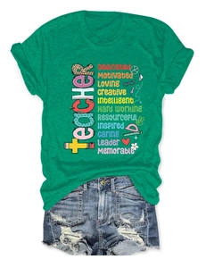Dettaglio della maglietta verde Teacher con scritte colorate e pantaloncini in denim