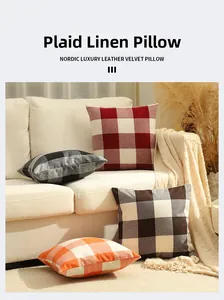 Detailaufnahme bunter Gingham-Leinenkissenbezüge auf einem weißen Sofa im gemütlichen Stil