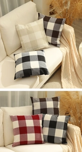 Detail der karierten Leinen-Kissenbezüge in verschiedenen Farben auf weißem Sofa