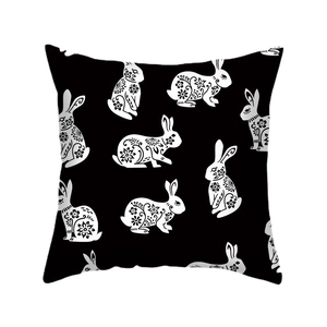 Black linen Easter pillow cover with white paper-cut style rabbit and floral patterns