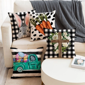 Set mit vier Oster-Leinenkissenbezügen mit Hasen- und Ei-Motiven auf einem beigen Sofa