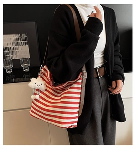 Detail of red striped canvas hobo bag with adjustable brown strap and cloud charm