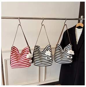 Detailed shot of striped canvas tote bags in red, black, and blue with cute cloud charms