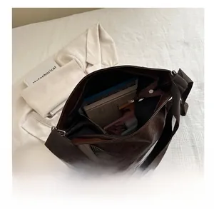 Vista dettagliata dell'interno di una borsa tote vintage marrone scuro con grande capacità