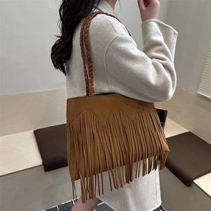 Bohemian brown suede tassel tote bag with braided handle shown in a modern interior setting