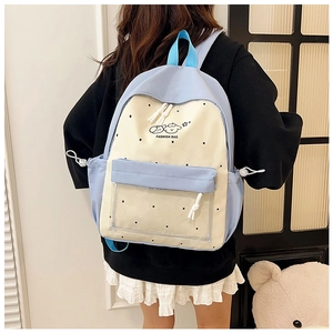 Detail of blue and beige polka dot backpack with clear front pocket and drawstring side pouches