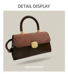 Detail of vintage brown leather handbag with suede flap and gold buckle in hand