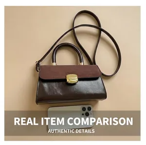 Detail of vintage two-tone handbag with gold clasp, shoulder strap and suede texture