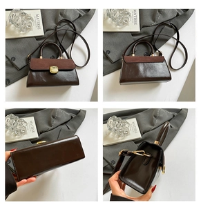 Detail of dark brown leather handbag featuring matte splicing and gold buckle closure