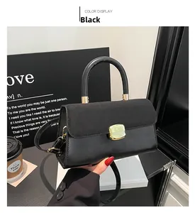 Detail of black crossbody bag with mixed leather textures and golden square buckle
