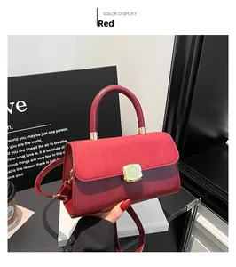 Detail view of red shoulder bag with suede flap and square gold metallic clasp