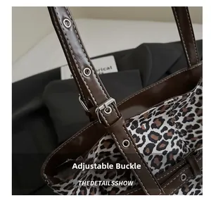 Detail of adjustable leather strap and metal buckle on leopard print tote bag