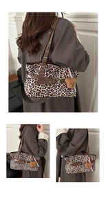Detail shot of leopard print faux suede tote bag with brown straps and plush bear charm