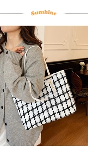 Bolso tote de lona a cuadros blancos y negros con correas de cuero blanco y remaches