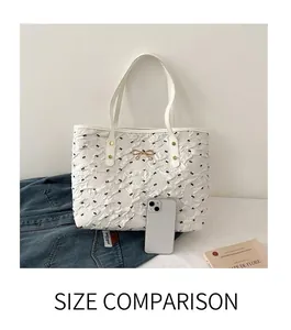Détail du sac cabas blanc avec motif nœuds, boucle dorée et poignée en cuir
