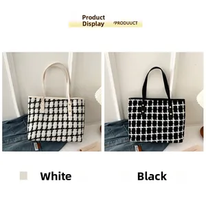 Detalle de bolsos tote tejidos a cuadros en blanco y negro con correas de cuero y remaches