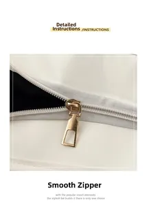 Détail d'une fermeture éclair dorée sur un sac en cuir blanc montrant la finition de luxe