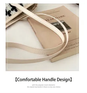 Primer plano de bolso de pata de gallo con asas de cuero sintético beige y costuras finas