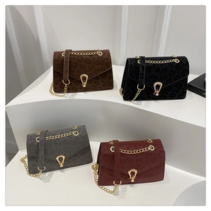 Detail of leopard print crossbody bags with golden teardrop buckles and chain straps