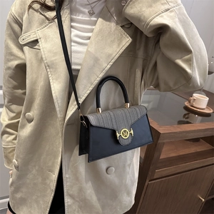 Fashionable grey texture crossbody bag with gold M buckle on beige trench coat