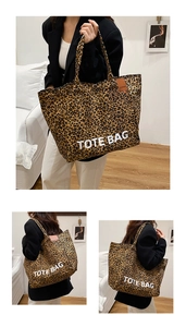 Detail of leopard print canvas tote bag with white text and brown leather side tag