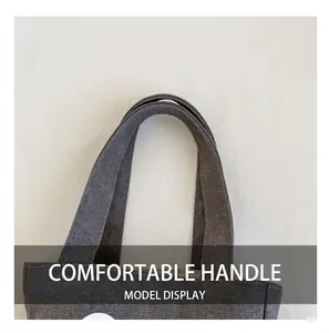 Detail view of reinforced stitching on deep gray canvas tote bag handles