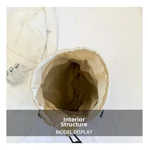 Macro shot of the spacious internal structure of this cream drawstring shoulder bag