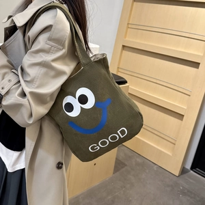 Army green canvas tote bag featuring a cute cartoon smiley face and GOOD letter print