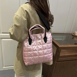 Sac cabas rose matelassé métallisé avec anses noires et porté avec un trench-coat beige
